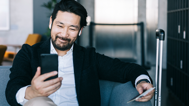 Man sitting on lounge looking at phone.