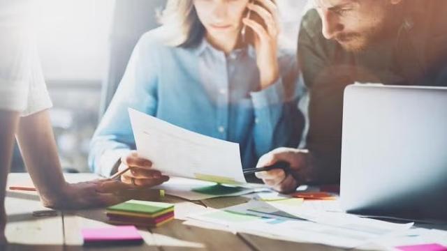 Co-workers working together representing essential planning tips for business travel.