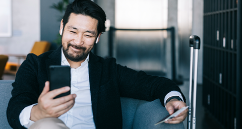 Man sitting on lounge looking at phone.