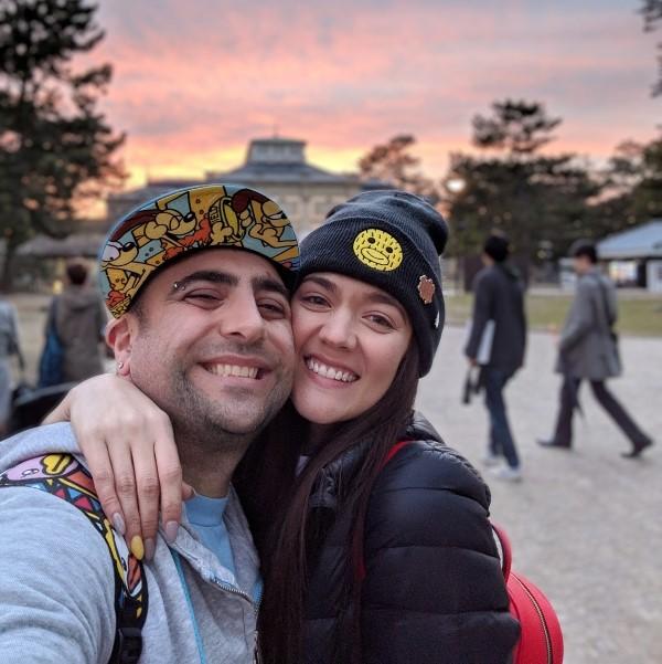 couple standing in front of a beautiful sunset on vacation