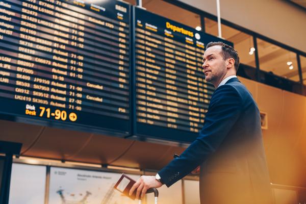 Businessman looking at arrival departure board in airport