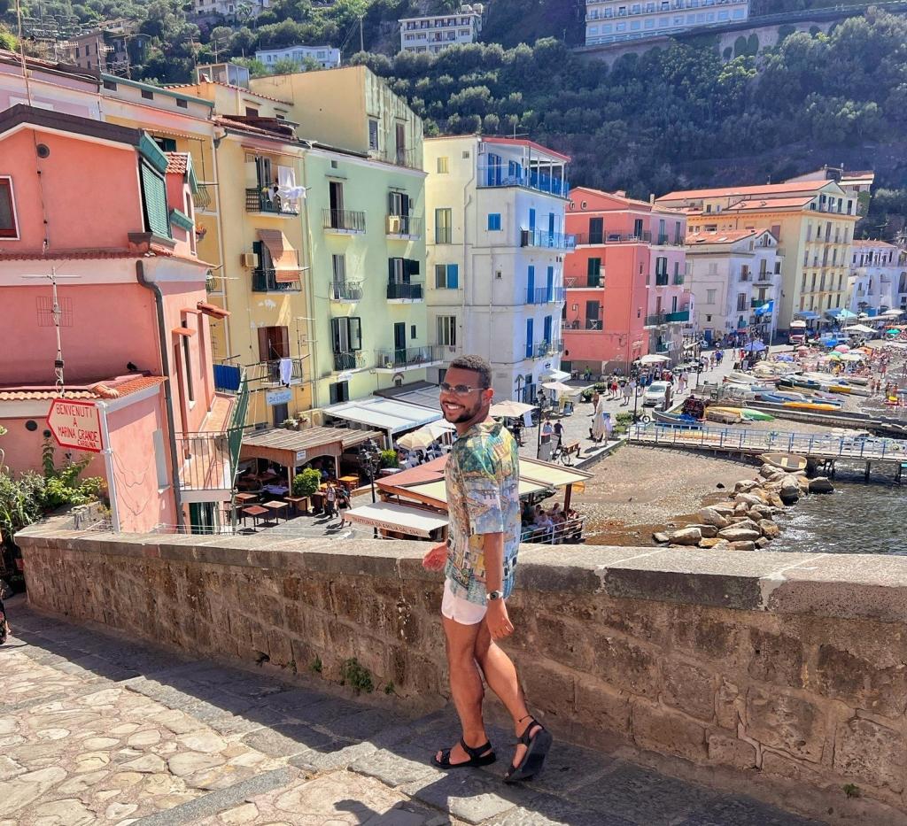man on vacation on a bridge with colourful buildings in the background