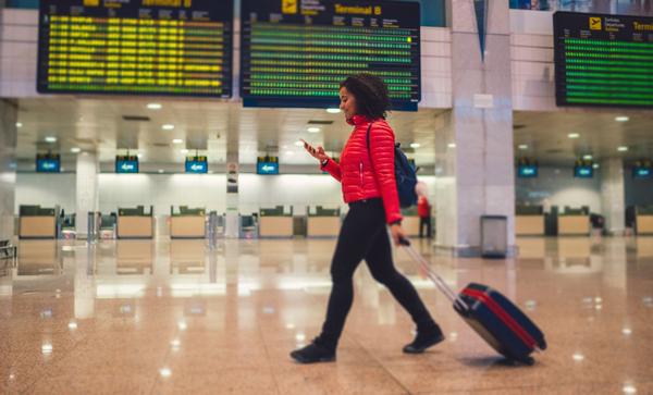 Mixed race woman texting at the airport terminal
