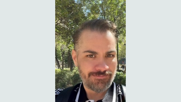 Man with beard in a park taking a selfie