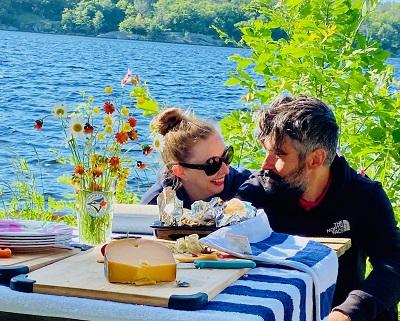 woman and man sitting lakeside smiling at eachother