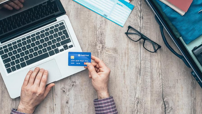 Man using credit card to pay online representing the use of online booking tools for business travel.