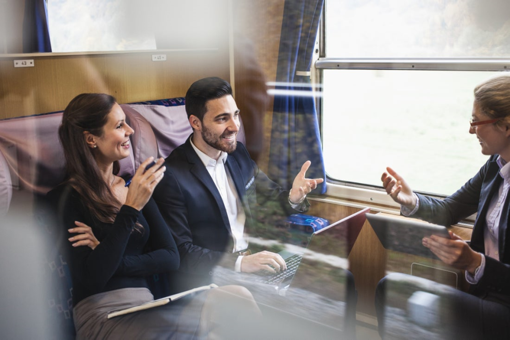 three people talking on a train
