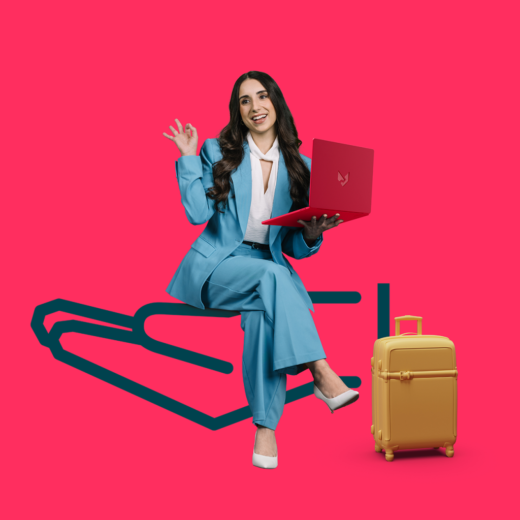 woman on a laptop with a suitcase beside her