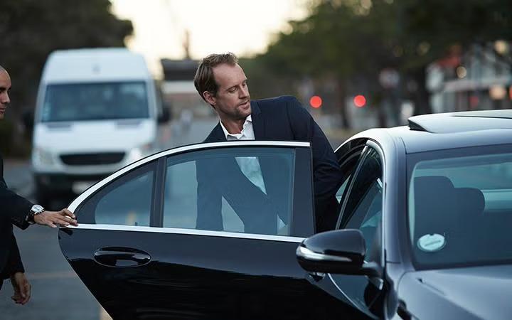 A man stepping into a car demonstrating how to leverage corporate travel discounts to maximise your savings.