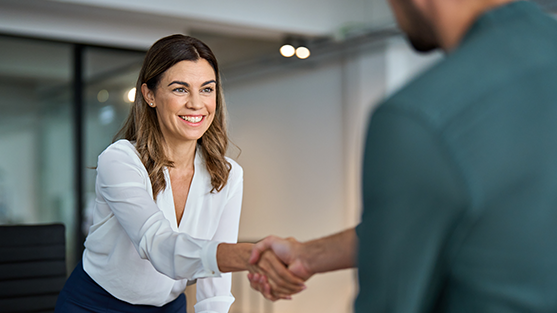 A man and woman shaking hands representing how Corporate Travellers Expert Onboarding program ensures a solid foundation for your new travel program and makes change management quick and easy.