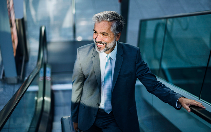 Man smiling going up escalator