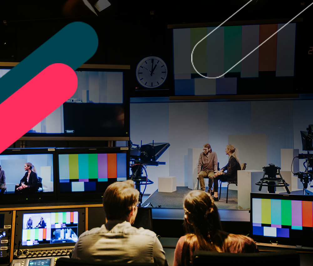 Broadcast control room staff watching presenters on stage via multiple screens.