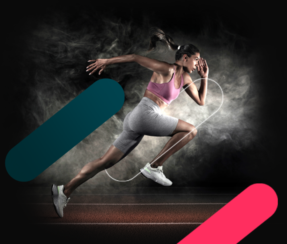 Female sprinter in pink sports bra and white shorts on track with smoky, dynamic light trails