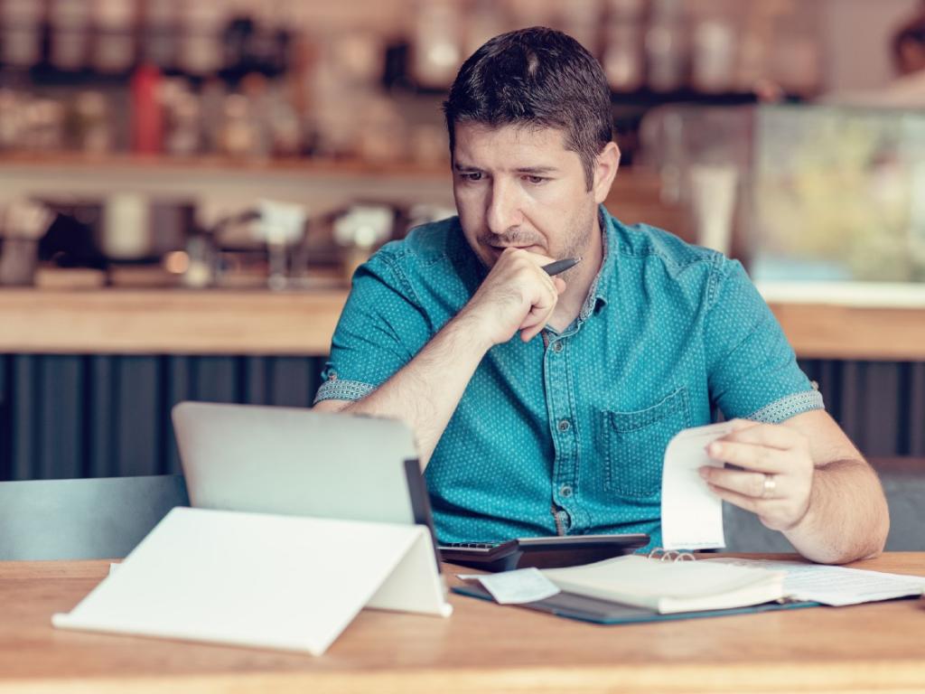 Man checking expense receipts with ipad